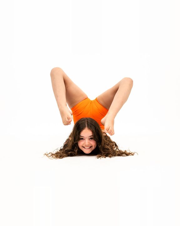 Acro dancer smiling in a chest stand