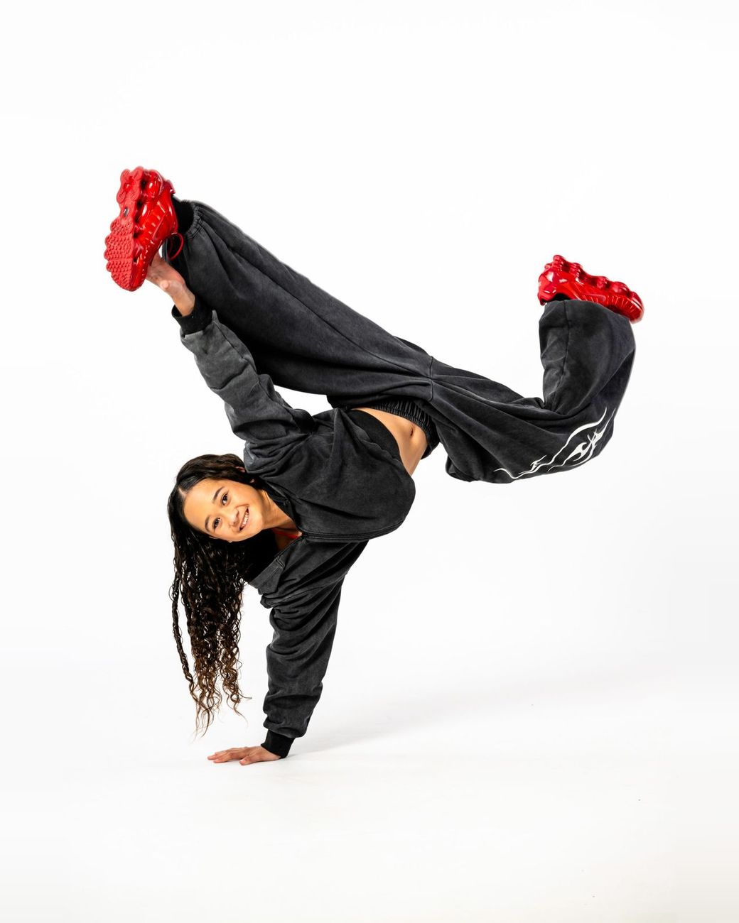Hip hop dancer in a one-hand freeze in red sneakers