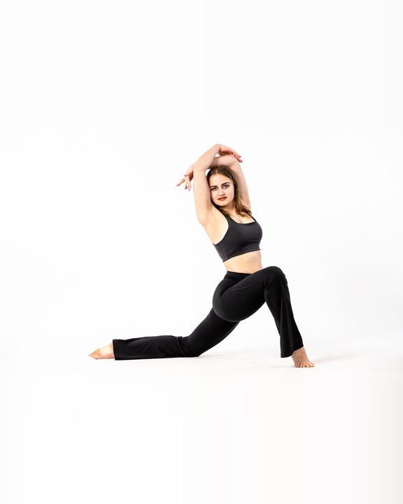 Dancer in a deep lunge with arms raised